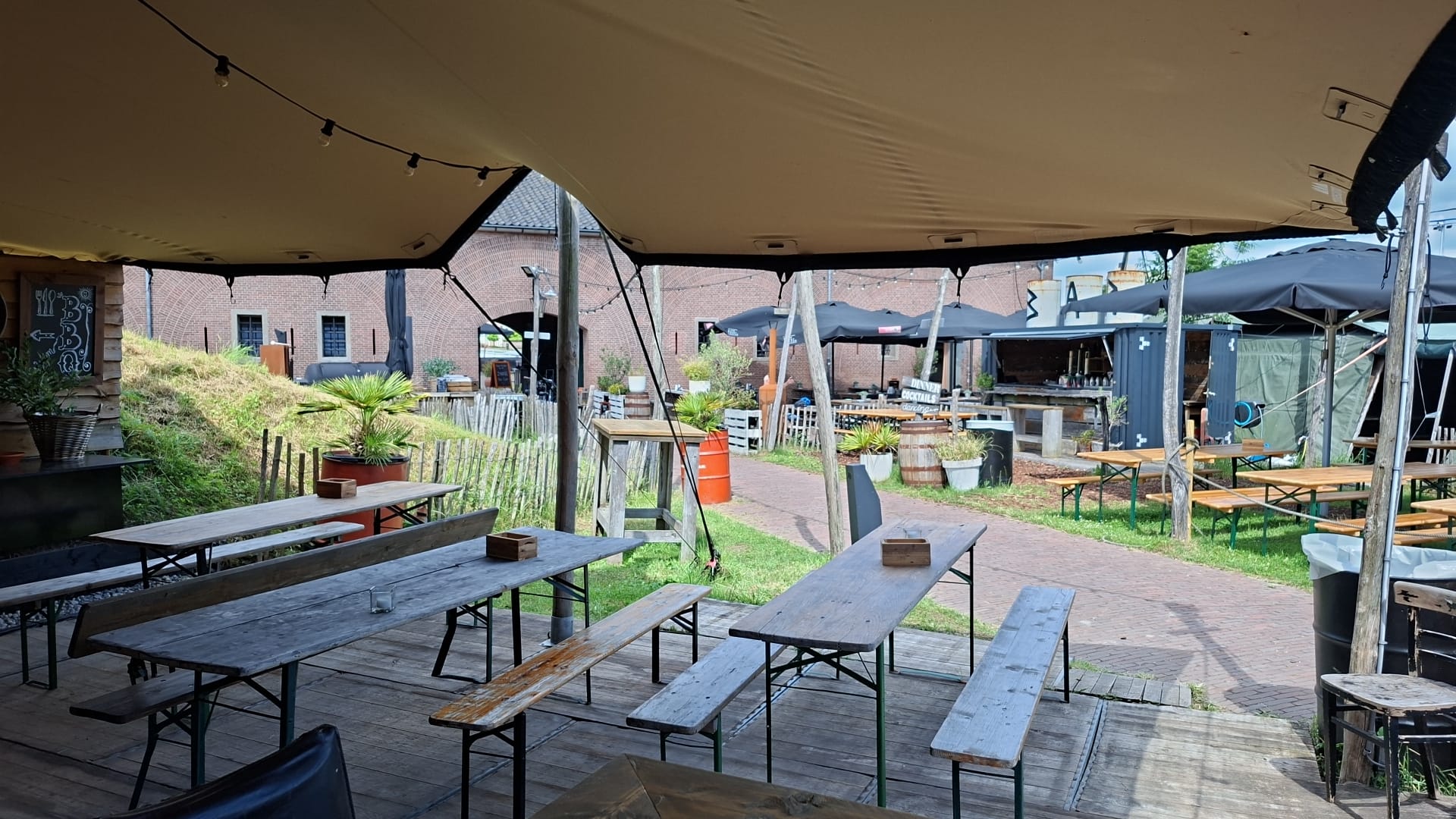 Overdekte tent met houten tafels op het fortterrein